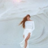 A suit with top an asymmetric neck and a scented skirt milk